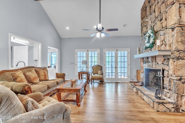 226 Auburn Dr, Alexander City, AL 35010 - living room featuring high vaulted ceiling, light wood-type flooring, a ceiling fan, a fireplace, and french doors