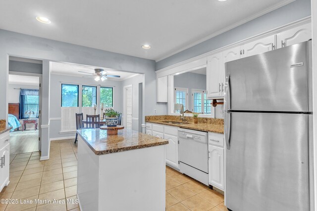 226 Auburn Dr, Alexander City, AL 35010 - kitchen featuring freestanding refrigerator, white dishwasher, a center island, light tile patterned flooring, and white cabinets