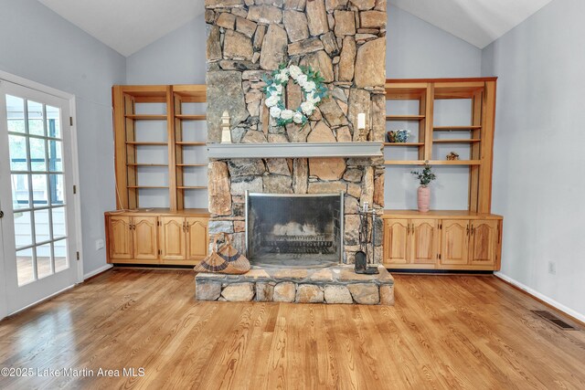 226 Auburn Dr, Alexander City, AL 35010 - living area featuring lofted ceiling, wood finished floors, and a stone fireplace