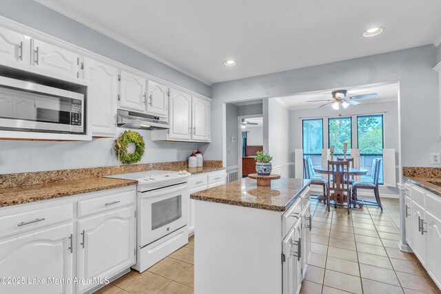 226 Auburn Dr, Alexander City, AL 35010 - kitchen featuring white electric stove, under cabinet range hood, stainless steel microwave, ceiling fan, and a kitchen island