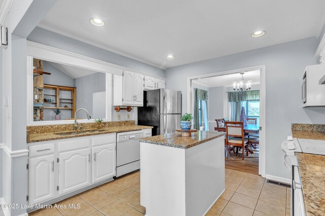 226 Auburn Dr, Alexander City, AL 35010 - kitchen with dishwasher, freestanding refrigerator, white cabinets, a kitchen island, and light tile patterned flooring