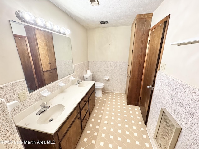 2821 Hillabee Rd, Alexander City, AL 35010 - bathroom with wainscoting, a sink, tile walls, and a textured ceiling
