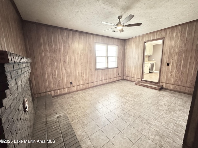 2821 Hillabee Rd, Alexander City, AL 35010 - empty room with wood walls, crown molding, baseboards, a textured ceiling, and ceiling fan