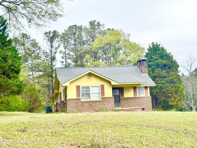 2821 Hillabee Rd, Alexander City, AL 35010 - ranch-style house with roof with shingles, central AC unit, a front yard, brick siding, and a chimney