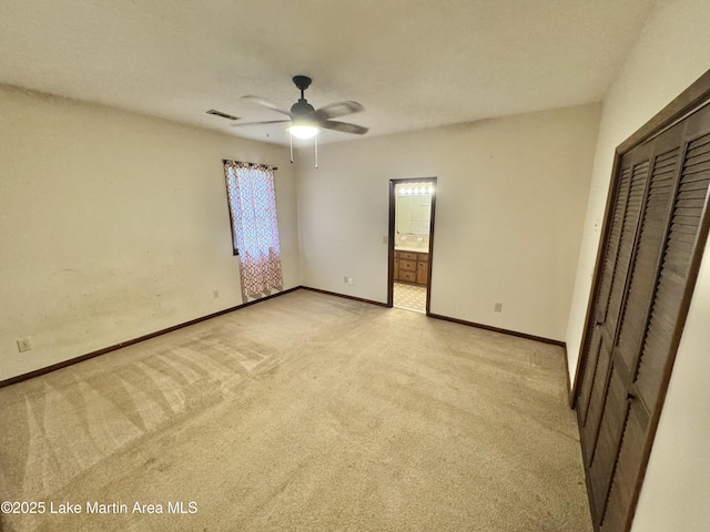 2821 Hillabee Rd, Alexander City, AL 35010 - unfurnished bedroom featuring a closet, visible vents, baseboards, connected bathroom, and light carpet