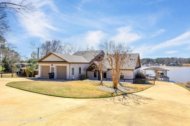 view of front of home featuring a front yard, driveway, stucco siding, a gazebo, and a garage