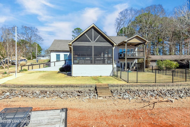 rear view of house featuring stairs, a yard, a fenced backyard, and a sunroom