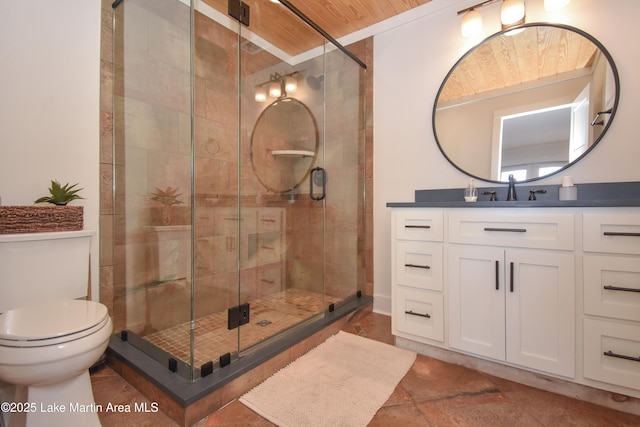 full bathroom featuring a shower stall, toilet, and vanity