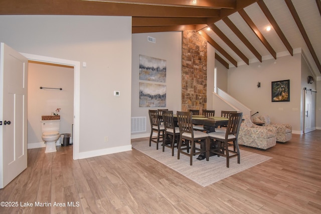 dining space with visible vents, beam ceiling, high vaulted ceiling, wood finished floors, and baseboards