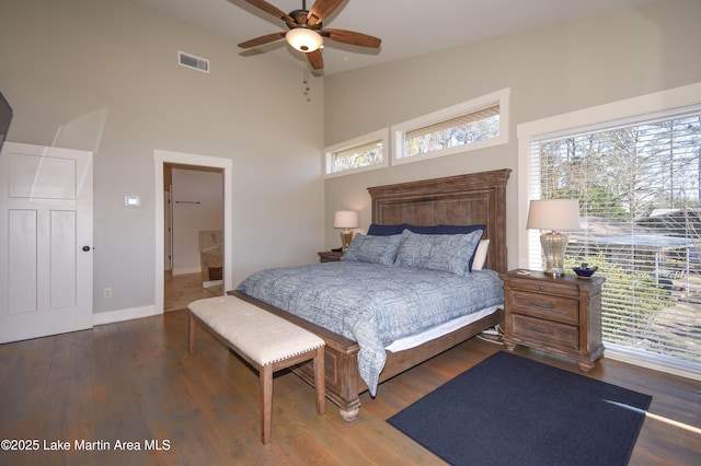 bedroom featuring visible vents, multiple windows, high vaulted ceiling, and wood finished floors