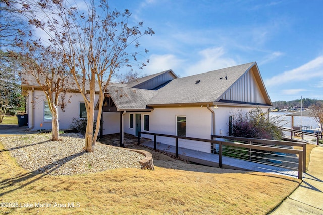 view of front of home with a front yard and roof with shingles