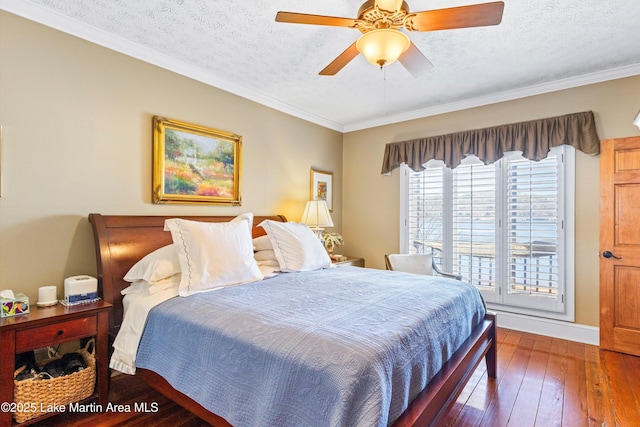 bedroom with ceiling fan, ornamental molding, dark wood-type flooring, and a textured ceiling