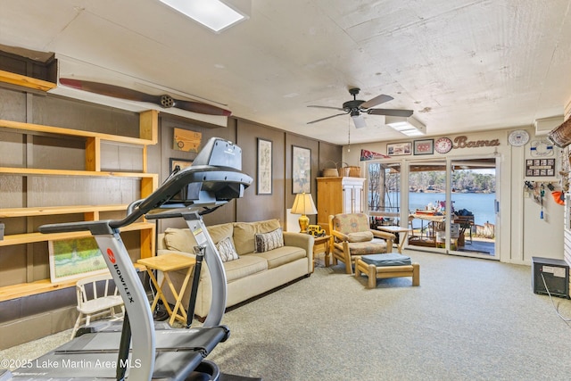 living room featuring ceiling fan, a water view, and carpet floors