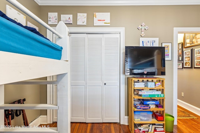 interior space with a closet, ornamental molding, and wood-type flooring