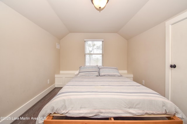 bedroom with dark hardwood / wood-style flooring and lofted ceiling