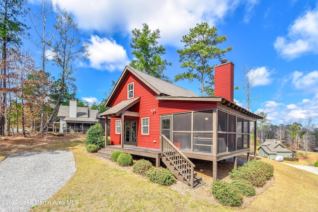 view of front of house featuring a sunroom and a front yard