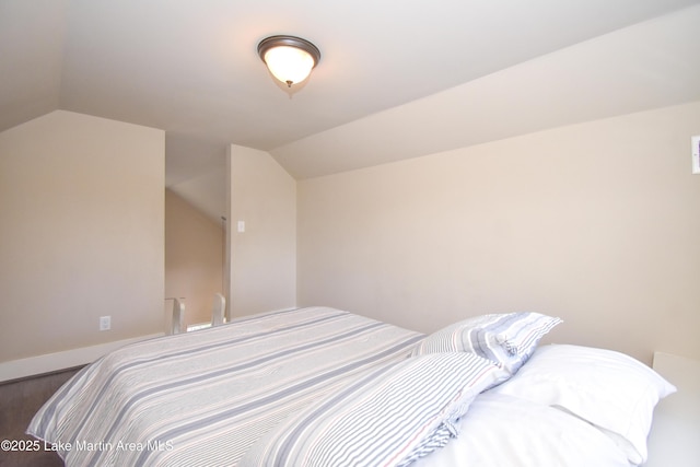 bedroom with wood-type flooring and vaulted ceiling