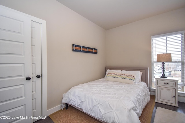 bedroom with dark hardwood / wood-style flooring and lofted ceiling