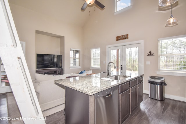 kitchen with dark brown cabinets, sink, high vaulted ceiling, dishwasher, and an island with sink