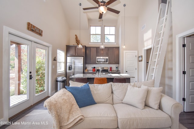 living room with a wealth of natural light, ceiling fan, high vaulted ceiling, and french doors