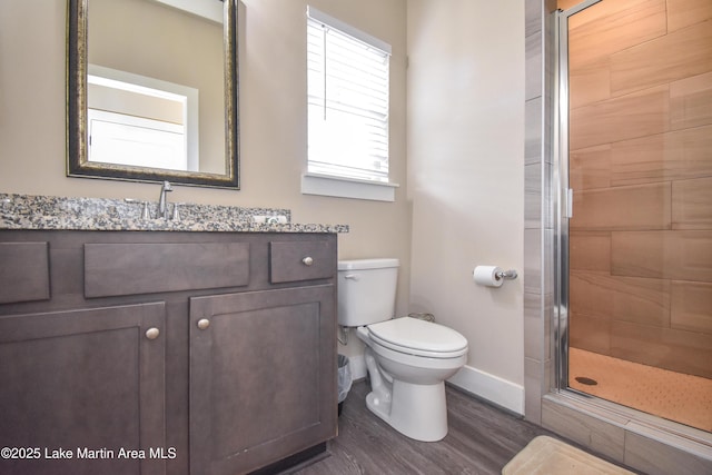 bathroom featuring vanity, wood-type flooring, an enclosed shower, and toilet