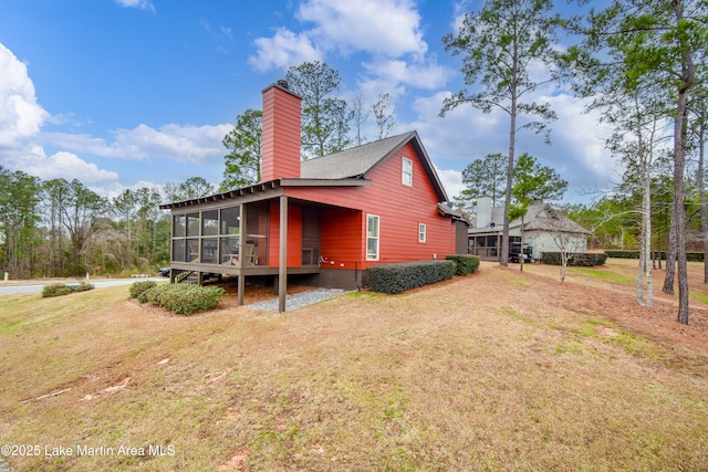 view of property exterior featuring a sunroom and a yard