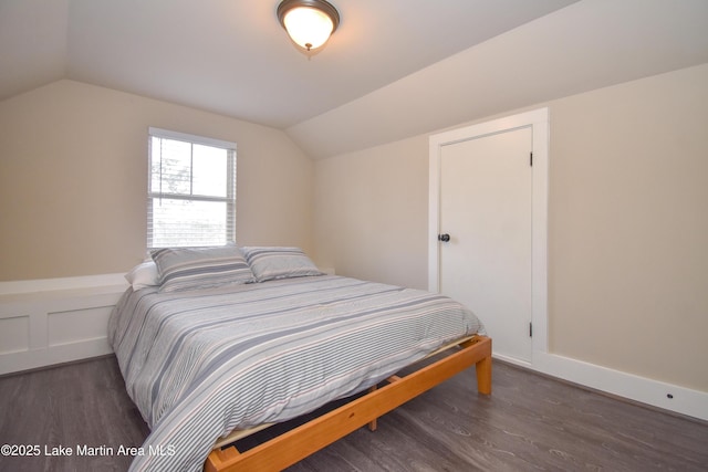 bedroom with dark hardwood / wood-style flooring and vaulted ceiling