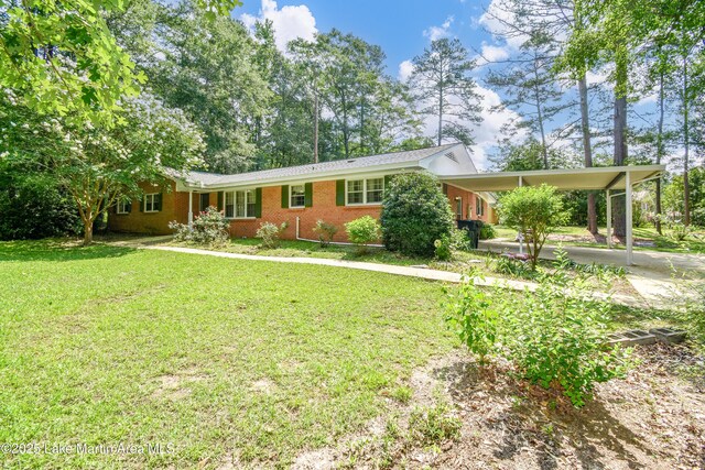 300 Hornsby Dr, Tallassee, AL 36078 - ranch-style house with a front yard, brick siding, and a carport