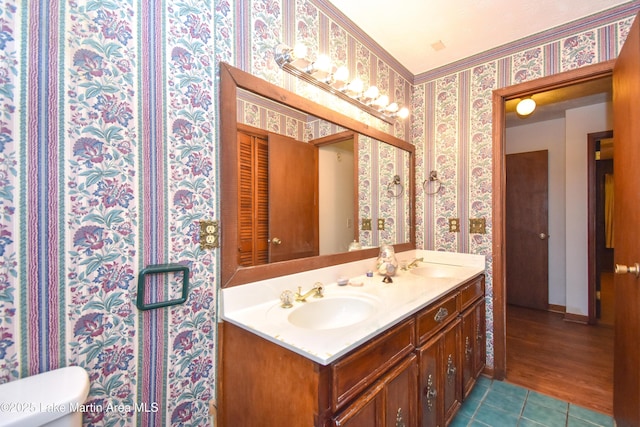 300 Hornsby Dr, Tallassee, AL 36078 - full bathroom featuring wallpapered walls, double vanity, tile patterned flooring, toilet, and baseboards