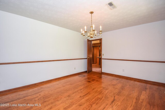 300 Hornsby Dr, Tallassee, AL 36078 - unfurnished room with a chandelier, wood finished floors, and baseboards