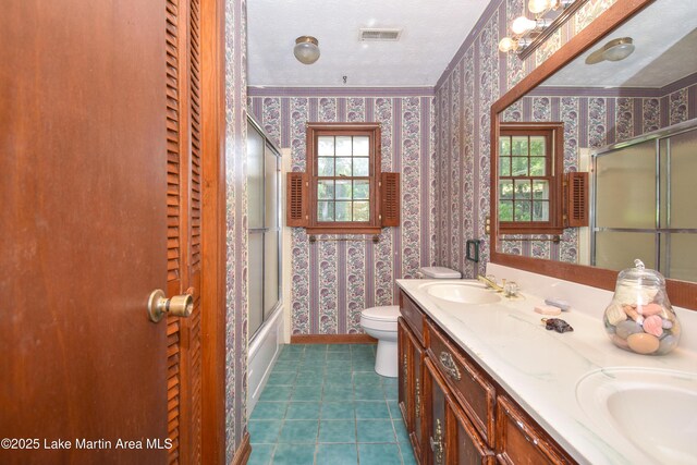 300 Hornsby Dr, Tallassee, AL 36078 - bathroom with wallpapered walls, toilet, double vanity, healthy amount of natural light, and baseboards