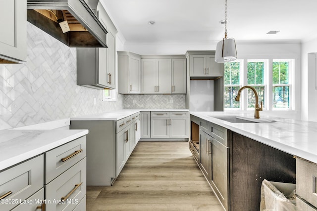 194 Oliver Way, Dadeville, AL 36853 - kitchen featuring premium range hood, gray cabinets, light wood-style floors, decorative light fixtures, and ornamental molding