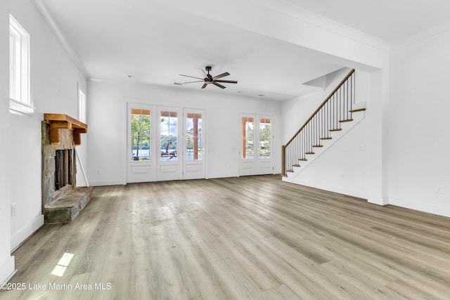 194 Oliver Way, Dadeville, AL 36853 - unfurnished living room with a stone fireplace, plenty of natural light, wood finished floors, and ornamental molding