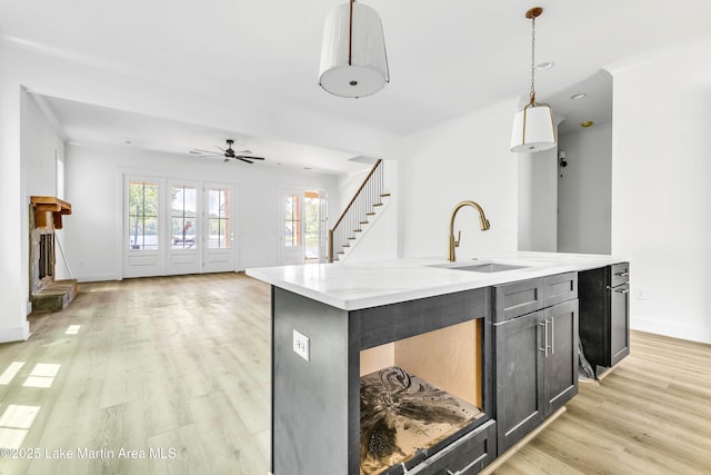 194 Oliver Way, Dadeville, AL 36853 - kitchen with light wood-type flooring, open floor plan, hanging light fixtures, a kitchen island with sink, and a ceiling fan