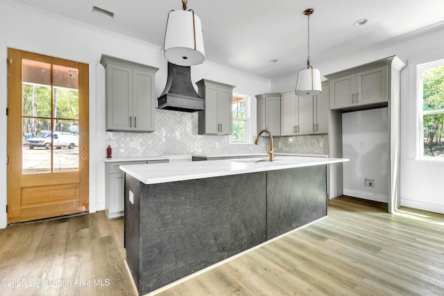 194 Oliver Way, Dadeville, AL 36853 - kitchen with gray cabinetry, light countertops, light wood-type flooring, decorative backsplash, and crown molding
