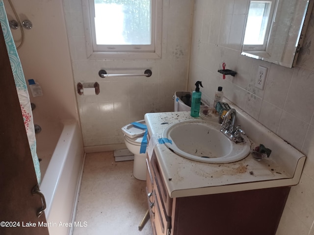 bathroom featuring vanity, toilet, and tile walls