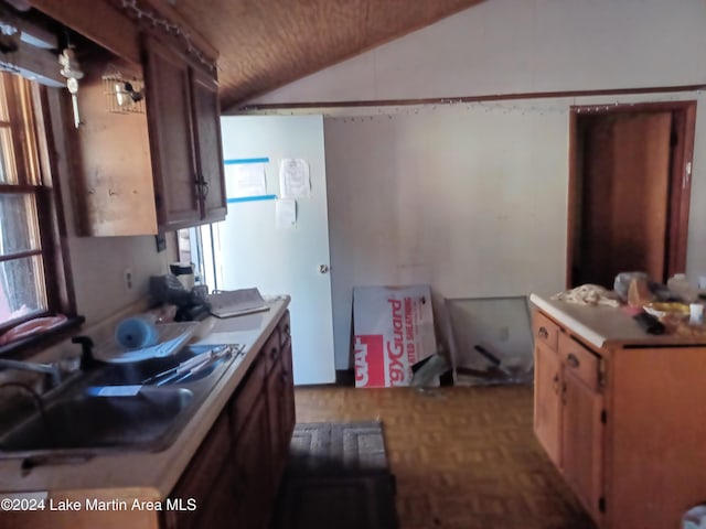 kitchen featuring parquet flooring, lofted ceiling, and sink