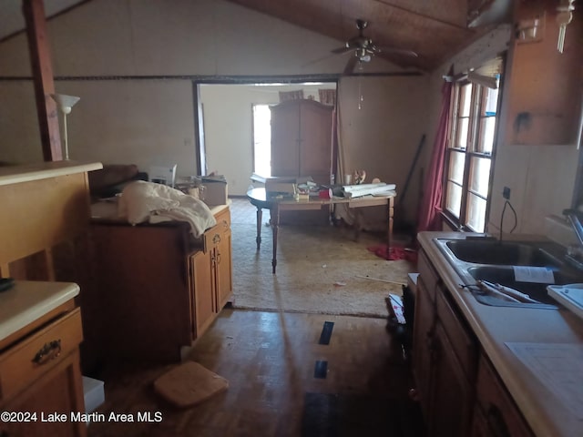 kitchen featuring ceiling fan, lofted ceiling, and sink