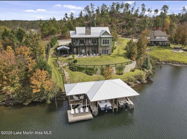 drone / aerial view with a water view and a forest view
