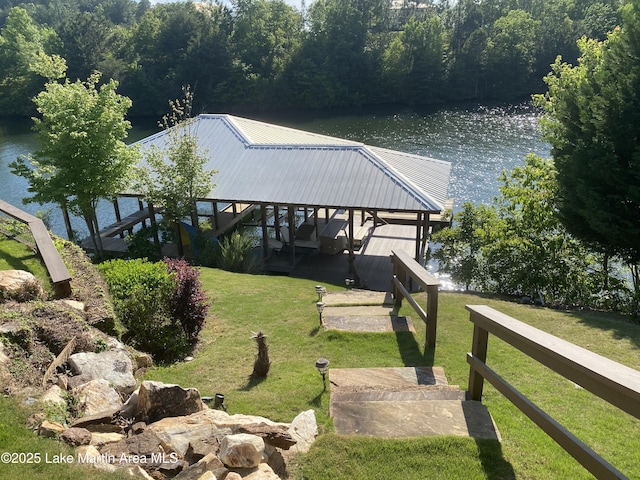 view of dock featuring a yard, a water view, and a view of trees