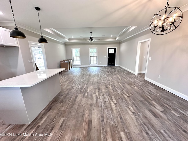 kitchen with dark hardwood / wood-style floors, white cabinetry, hanging light fixtures, and a tray ceiling