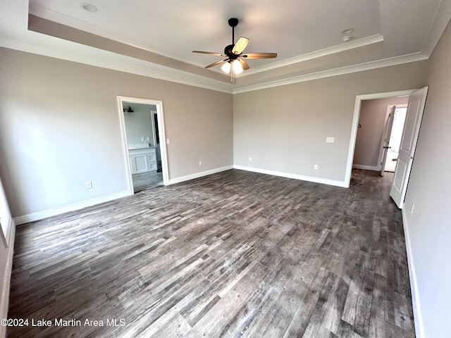 spare room featuring a tray ceiling, dark hardwood / wood-style floors, crown molding, and ceiling fan