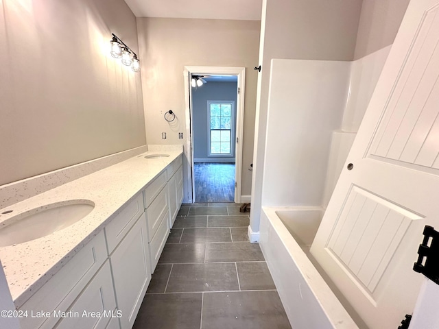 bathroom featuring tile patterned flooring, vanity, ceiling fan, and a tub to relax in