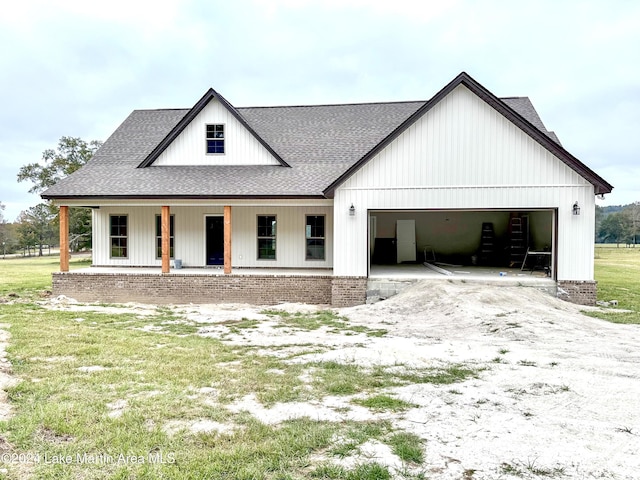 modern inspired farmhouse featuring covered porch and a garage