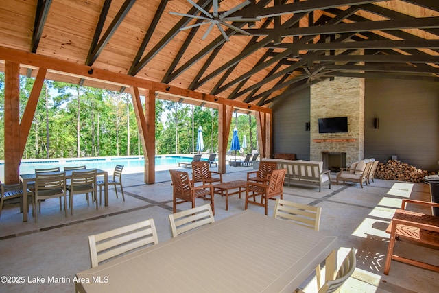 view of patio / terrace with a gazebo, ceiling fan, and an outdoor living space with a fireplace