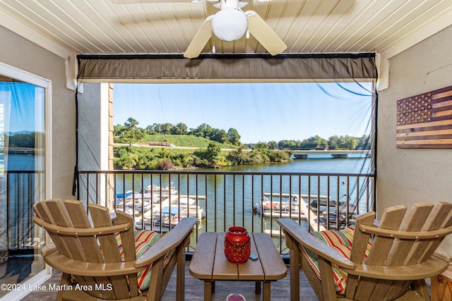 balcony featuring a water view and ceiling fan