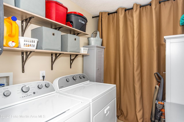 laundry room featuring a textured ceiling and washing machine and dryer