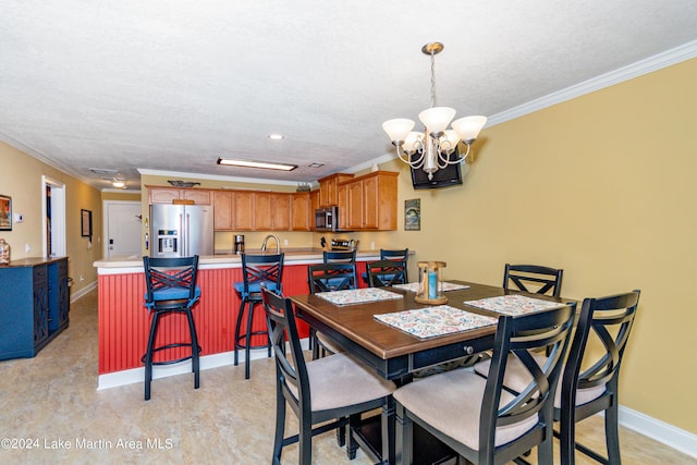 dining area with a notable chandelier, ornamental molding, and a textured ceiling