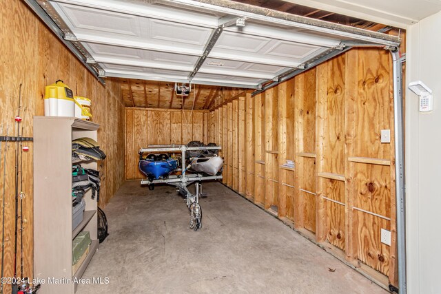 garage with wooden walls and a garage door opener