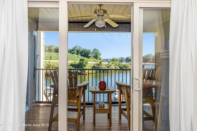 balcony with ceiling fan and a water view